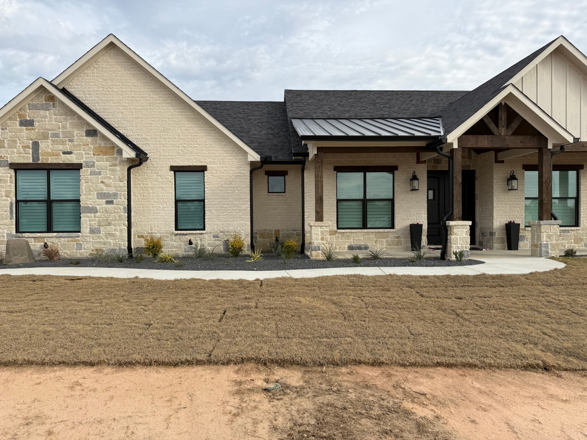 Texas stone home with Optex shutter-style solar screens on every window